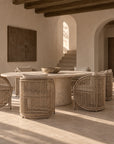 Cala Outdoor Dining Chairs with woven detailing and neutral cushions styled around a round dining table.