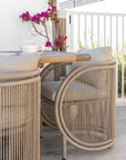 Cala Outdoor Dining Chair with woven detailing and neutral upholstery styled around an outdoor timber dining table.