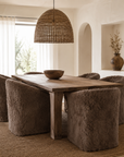 Hamilton dining chairs in Fur Luxe Chocolate upholstered in plush textured fabric styled around a rustic timber dining table beneath a woven pendant light.