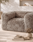 Close up of the Harlow one seater sofa in Biscuit featuring plush faux fur upholstery and rounded contemporary form in a softly styled neutral living space.
