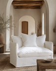 Singita Sofa One Seater in White styled in a warm Mediterranean inspired living room with natural timber, textured walls and earthy decor.