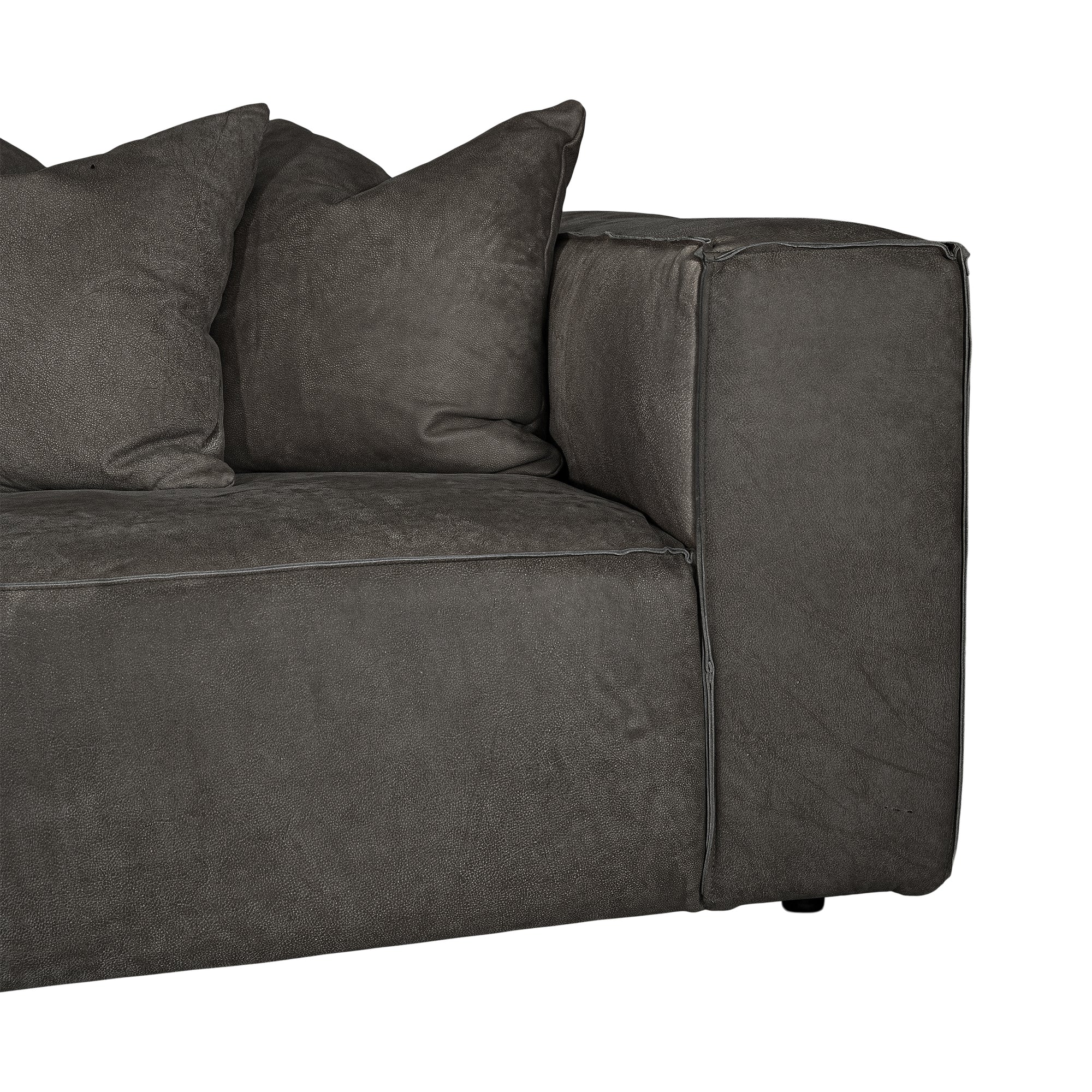 Close-up of a dark gray leather upholstered sofa corner with two matching throw pillows, shown against a plain white background.