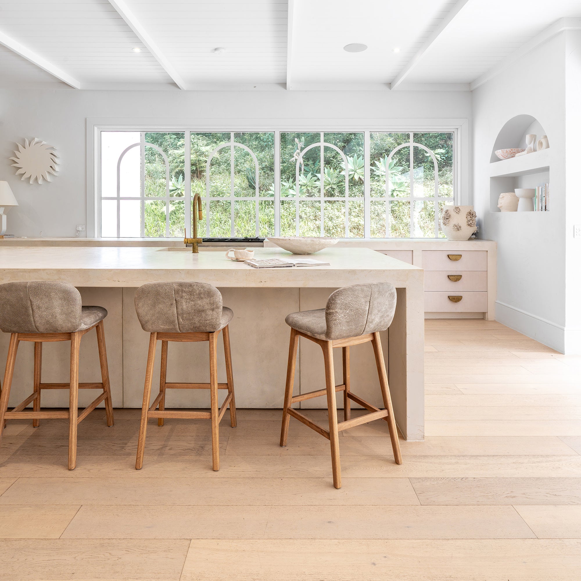 Modern rendered kitchen with an island and leather bar stools