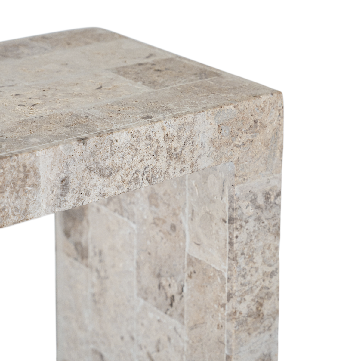 Duna Console Natural Fossil Stone close-up showing the tabletop edge, natural fossil markings and rectangular stone sections in soft beige tones.