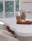 Interior view featuring Como Dining Chairs by Uniqwa Collections in Glam Luxe fabric around a sculptural white plaster dining table with curved lines
