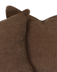 A close-up of two brown textured throw pillows on a solid white background.