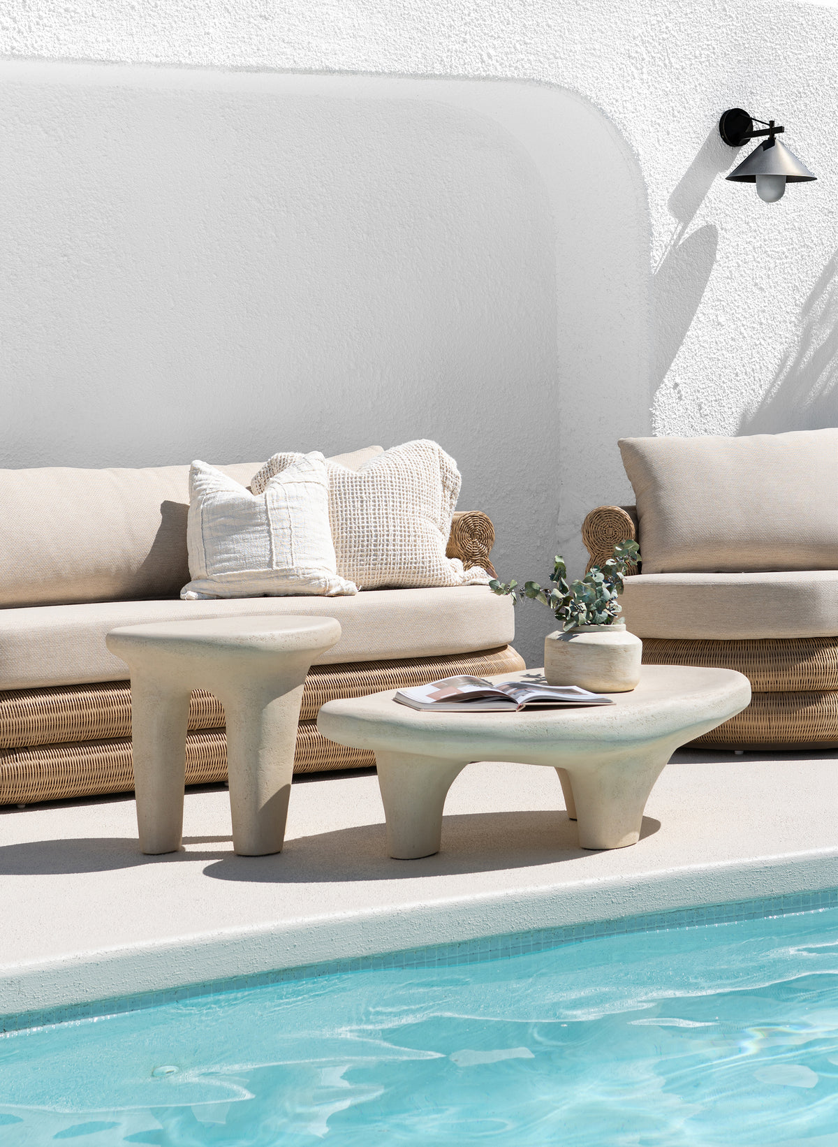 Bedu and Satori Collections styled poolside with woven outdoor seating and sculptural organic shaped tables.