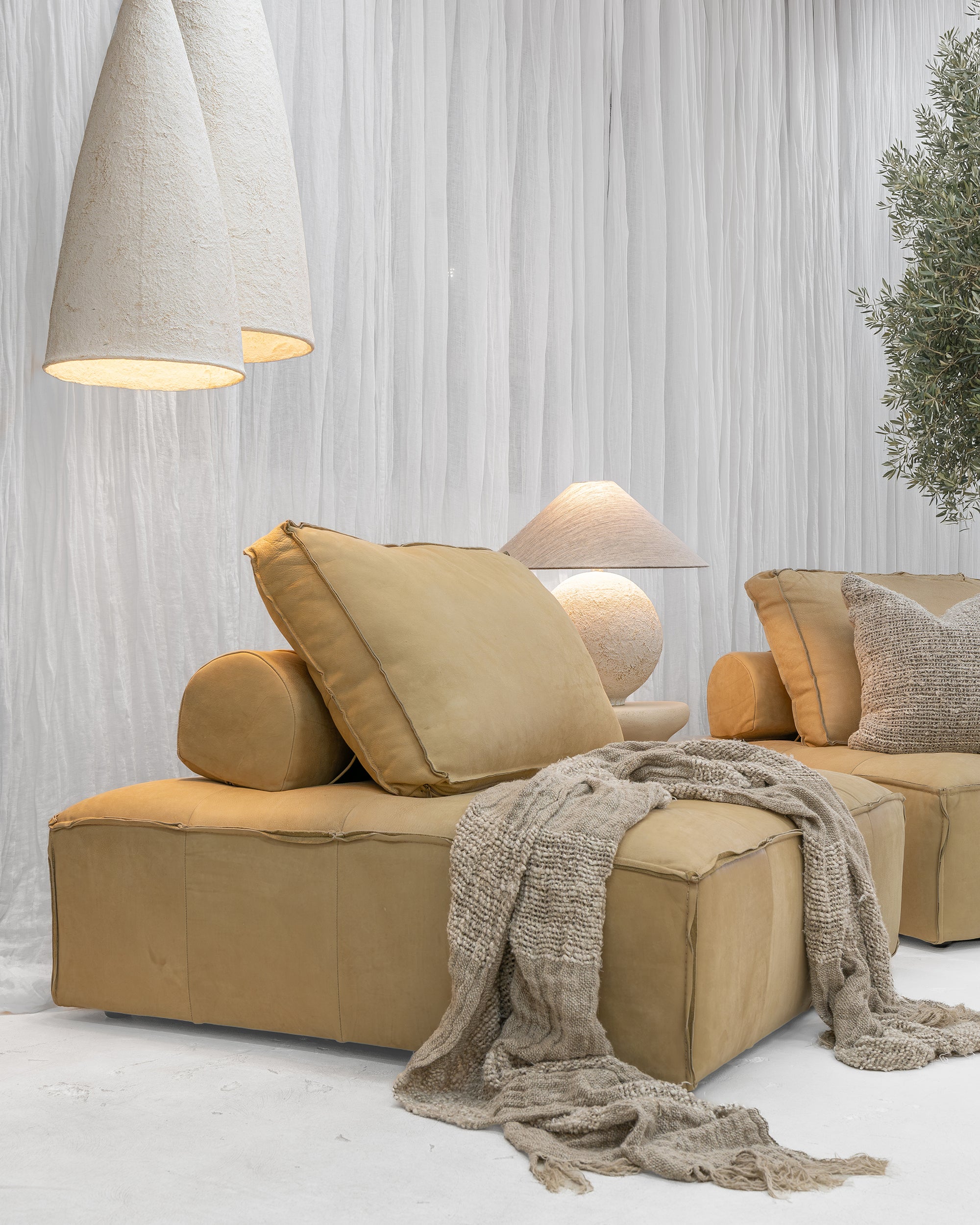 Sabi Table Lamp displayed on a Bedu Side Table alongside the Maui Sofa beneath a pair of Senah Pendants.