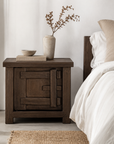 Bulu Bedside in Chocolate Elm styled beside a neutral bed with natural linen, sculptural ceramics and warm earthy accents.