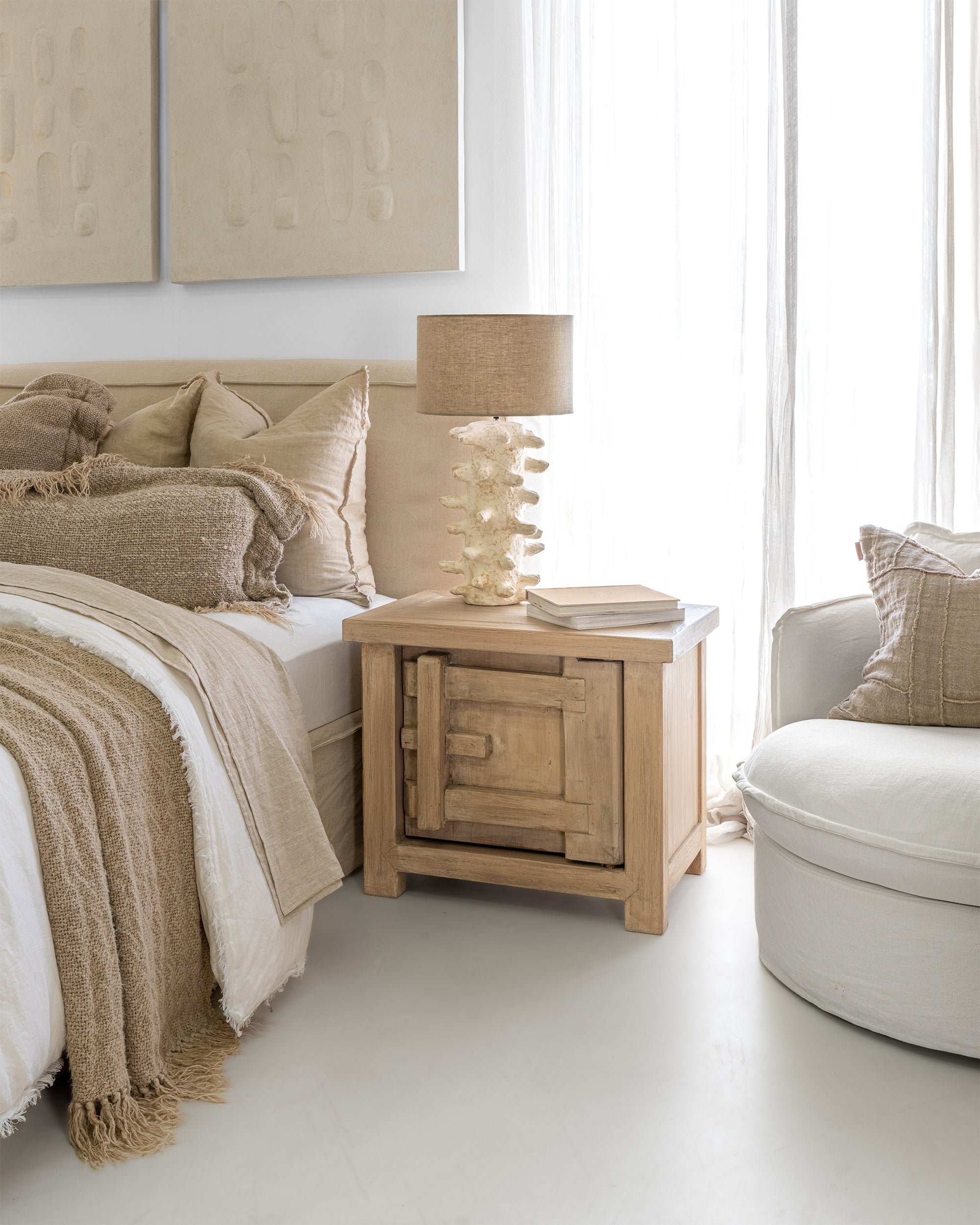 Bulu Bedside handcrafted from reclaimed pine styled beside, paper mache lamp and a linen bedhead in a light, neutral bedroom with soft natural textures.