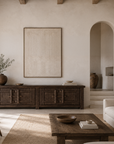 Bulu Four Door Entertainment Unit in Chocolate Elm styled in a warm neutral living room with sculptural ceramics, natural textures and arched architecture.