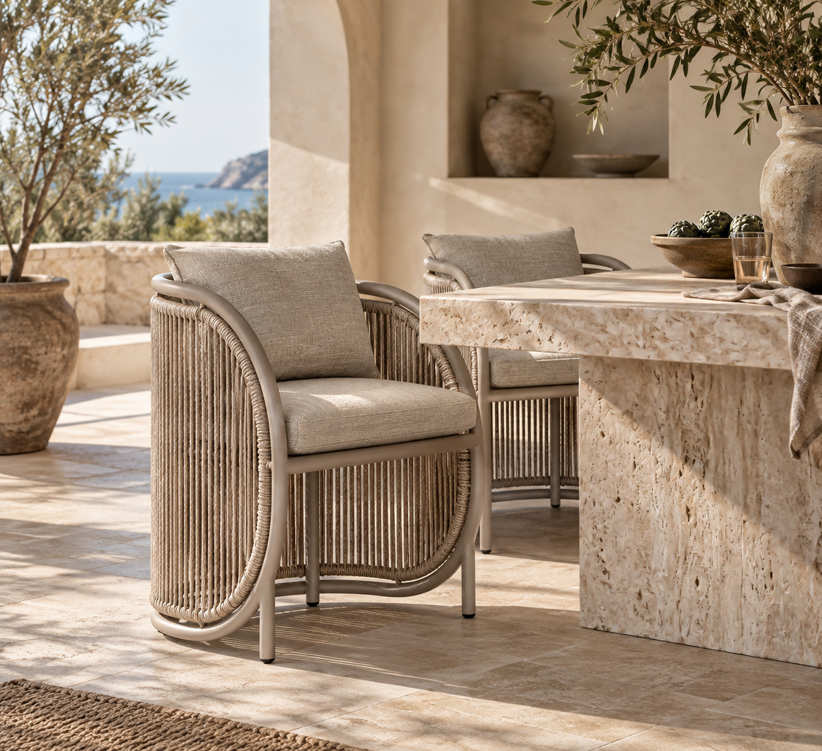 Cala Dining Chair with curved woven detailing and neutral upholstery, styled in a Mediterranean-inspired dining setting.