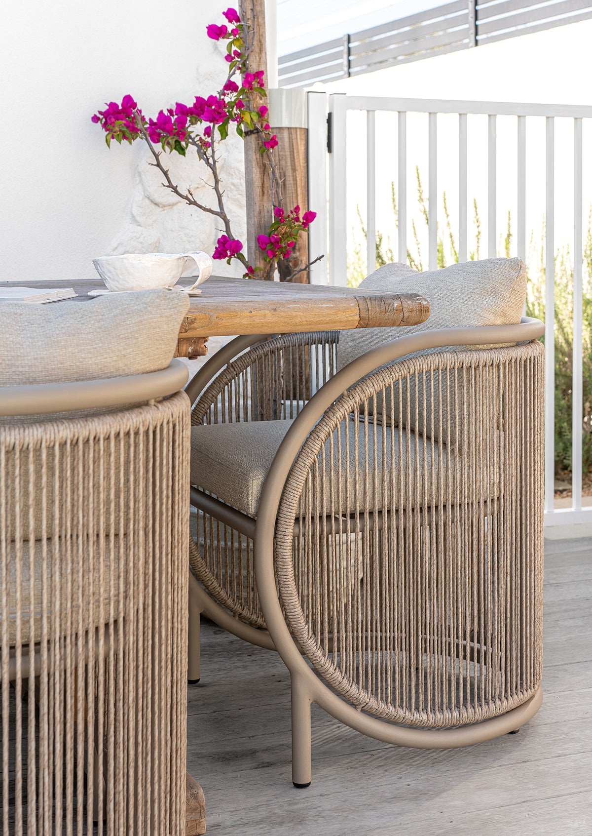 Cala Outdoor Dining Chair with woven detailing and neutral upholstery styled around an outdoor timber dining table.