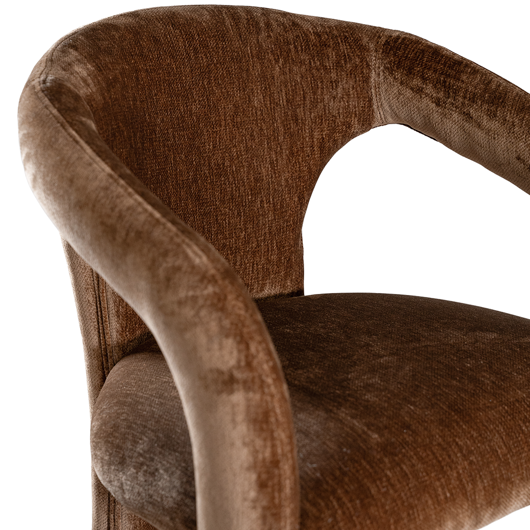Fikile barchair in bronze with a curved upholstered frame, rounded backrest and integrated footrest detail.