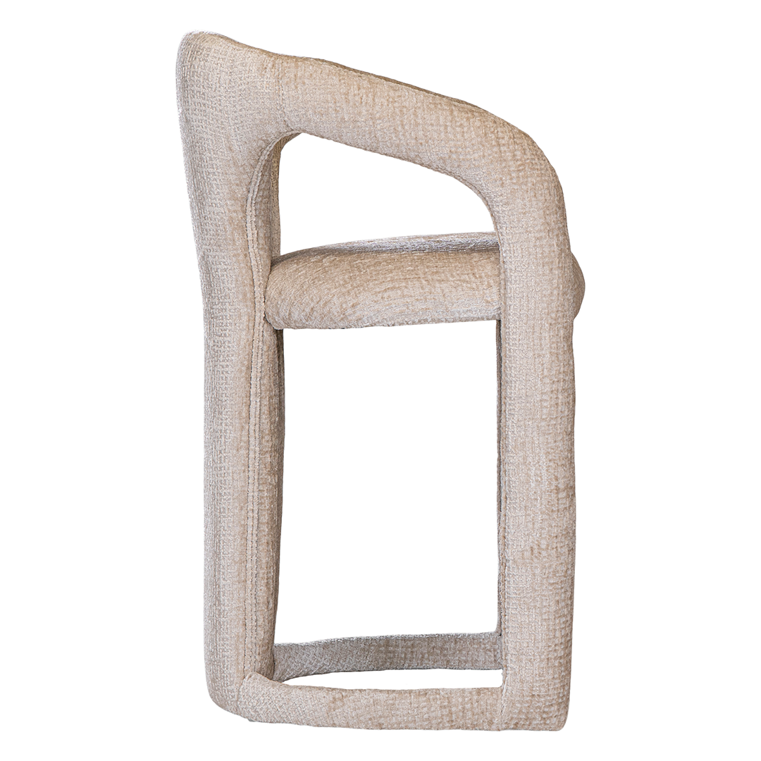 Fikile bar chair in sand mirage upholstery with a sculptural curved frame and integrated timber footrest detail.