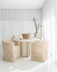 Salalah Dining Table in High Gloss Vanilla with Hamilton Dining Chairs in Fur Luxe, styled with the Nusa Palm Planter and Bloom Mug