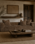 Harlow three seater sofa in chocolate with a plush textured finish styled in a warm Mediterranean inspired living room with rustic timber furniture and soft natural light.