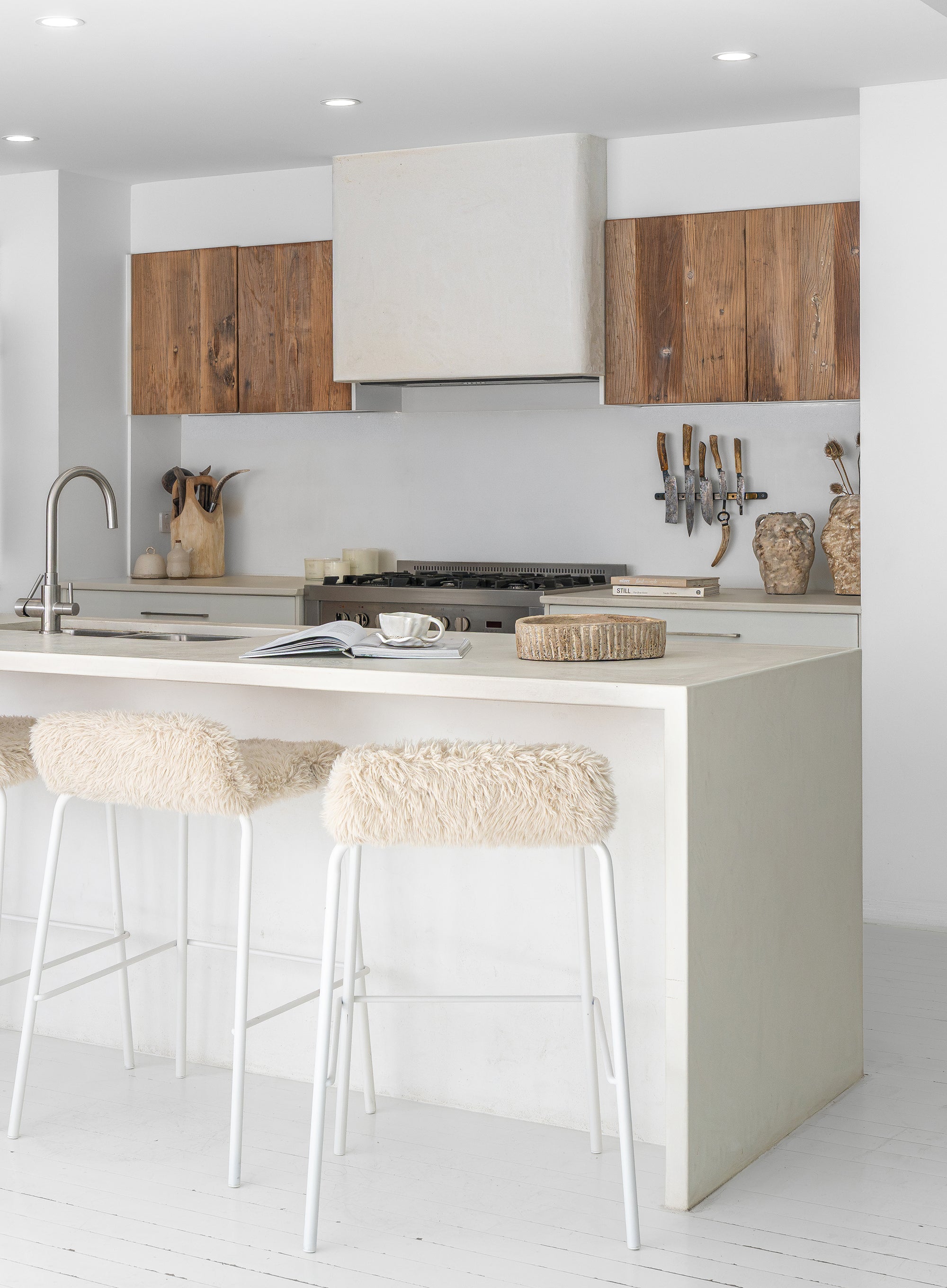 Hotham Barchairs arranged along a kitchen island with Ukoko Vases displayed behind and the Mayi Bowl styled on the benchtop.