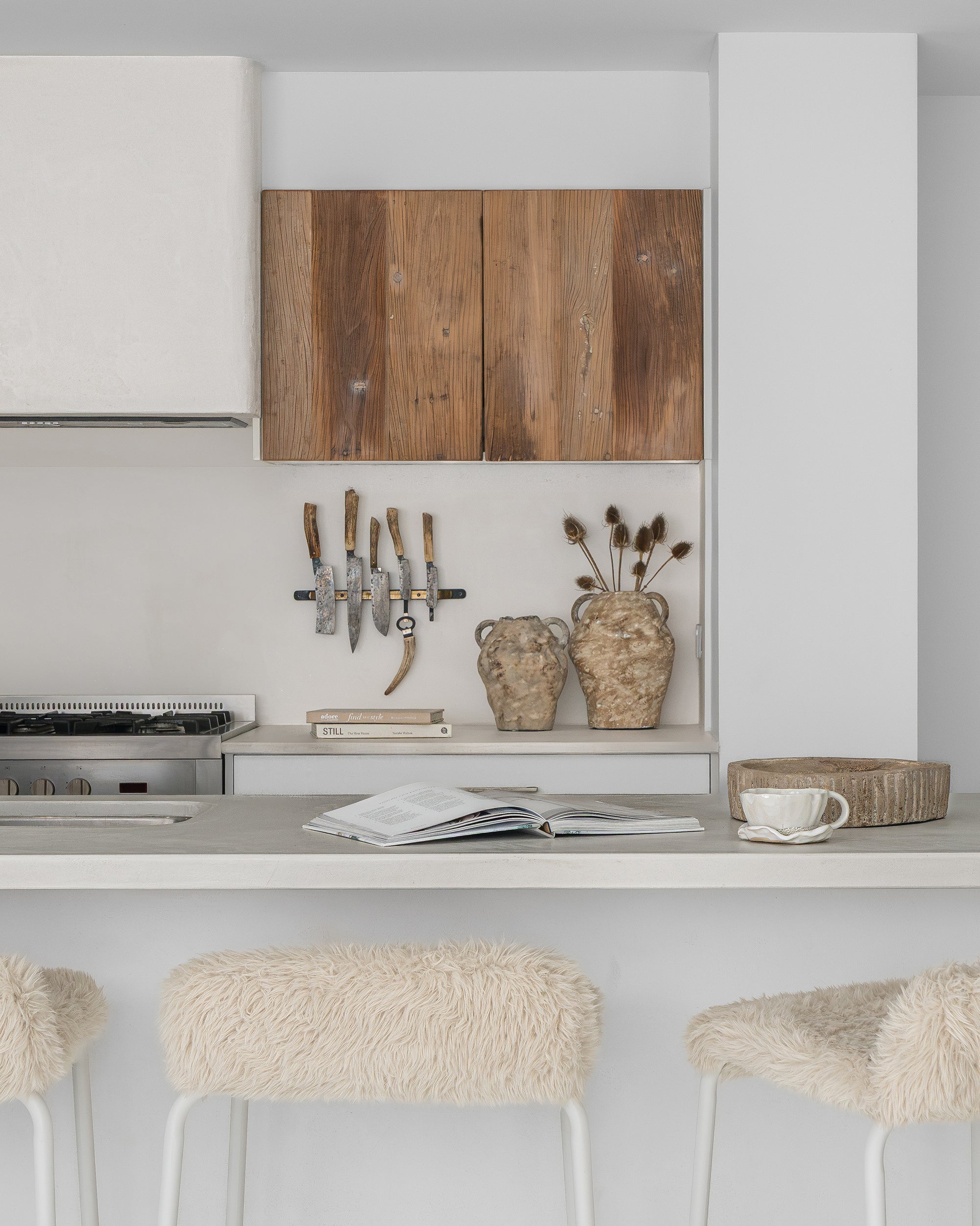 Hotham Barchairs at a white kitchen island with Ukoko Vases and the Mayi Bowl styled throughout the neutral kitchen setting.
