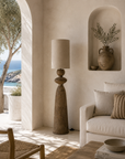 Jaala floor lamp natural fabric shade styled beside a sofa in a warm Mediterranean inspired living room.