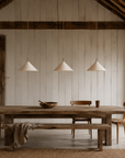 Khufu small pendant lights in Light Roast with textured shades suspended above a rustic timber dining table in a warm natural dining room.