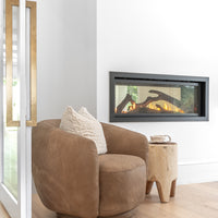 Leather swivel chair styled with a raw side table beside a modern fireplace, creating a warm and inviting corner with organic textures and natural elements