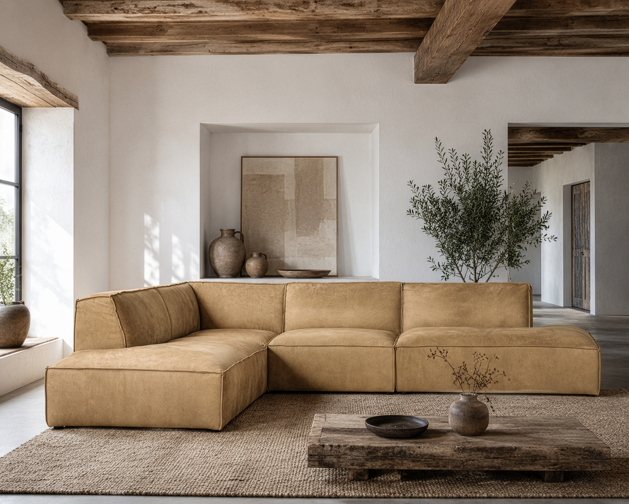 Manson modular sofa in cashew leather styled in a rustic living room with timber ceiling beams textured decor and warm natural tones