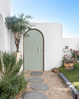 Nusa Palm Planter with an olive tree beside an arched entrance of a Mediterranean inspired home.