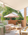 Oasis sofa with Maaru planter styled on a sunlit rooftop bar terrace with soft neutral tones textured seating and lush tropical greenery creating a relaxed outdoor setting