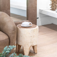 Raw teak side table styled beside a leather lounge, featuring a handcrafted ceramic cup and saucer, with a coral-inspired table lamp in the background, creating a warm and organic living space