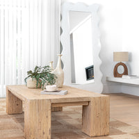 Uniqwa Collections a reclaimed wood coffee table styled with ceramic vases, greenery, and a sculptural cup, set in a bright living space featuring a statement mirror, neutral tones, and natural textures for a modern organic aesthetic