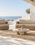 Satori Swivel Chair and Satori Sofa with natural woven frames and neutral cushions in a coastal outdoor living setting.