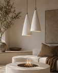 Senah Pendant lights shown as a pair, highlighting their textured conical shades suspended above a warm, minimalist living space
