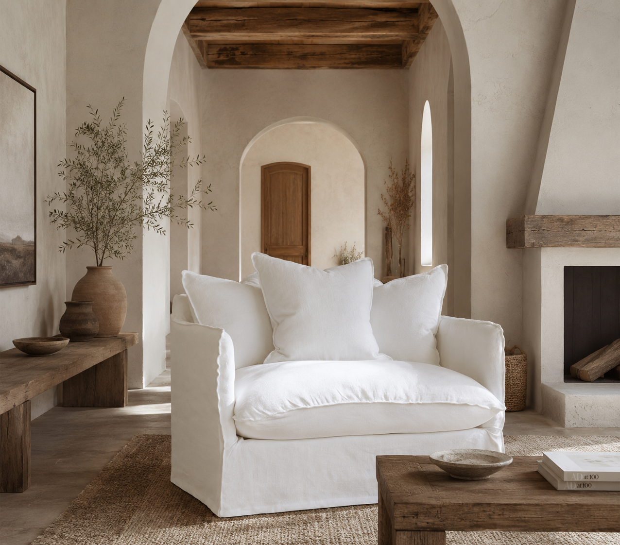 Singita Sofa One Seater in White styled in a warm Mediterranean inspired living room with natural timber, textured walls and earthy decor.