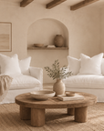 Two Singita Sofa One Seater chairs in White styled in a warm neutral living room with natural timber, textured furnishings and Mediterranean inspired architecture.