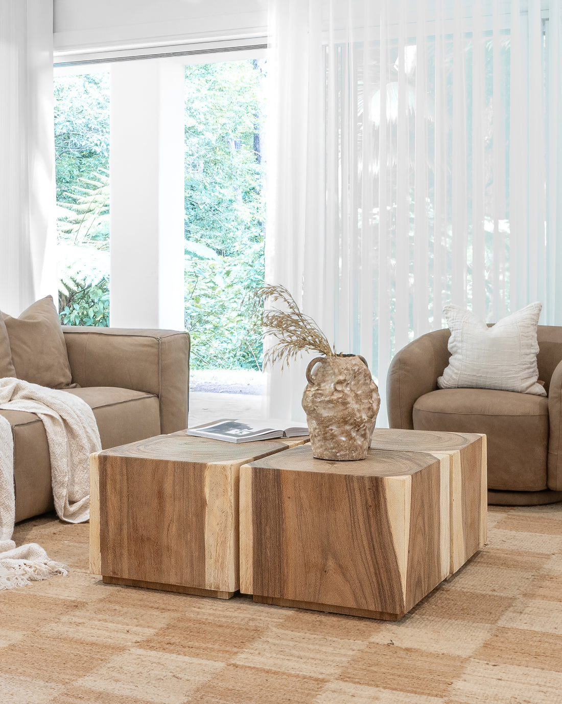 Modern organic living room featuring a solid wood coffee table with a natural finish, complemented by plush leather sofas and a textured neutral rug for a warm, inviting ambiance