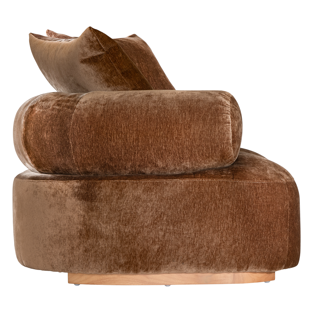 Soneva one seater sofa in bronze fabric featuring a soft curved silhouette with round bolster cushions and plush back pillows.