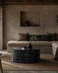Thembu coffee table in black with a sculptural layered silhouette styled in a moody contemporary living room with earthy textures and natural accents.