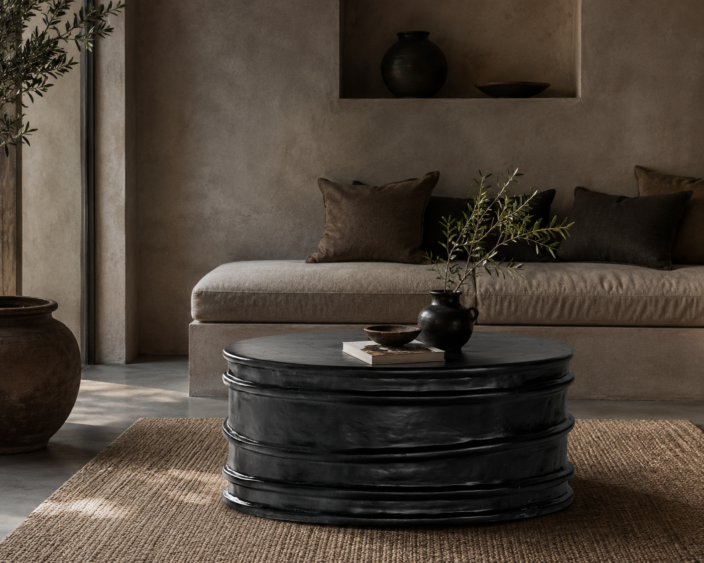 Thembu coffee table in black with a sculptural layered silhouette styled in a moody contemporary living room with built in seating, earthy textures and natural accents.
