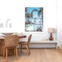 Timber dining table styled with leather dining chairs, a sculptural bowl, and textured cushions, complemented by a coastal-inspired wall art piece and a warm-toned wooden table lamp in a refined dining nook