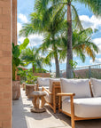 Tsuana stool styled on a sunlit rooftop terrace with timber lounge seating soft neutral cushions and surrounding tropical greenery creating a relaxed outdoor retreat