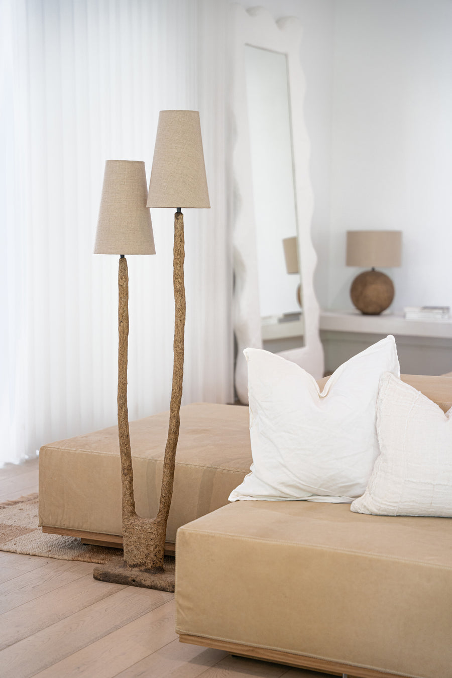 A sculptural twin floor lamp with textured paper mache stems and natural linen shades, styled in a serene living space with neutral-toned furnishings and organic textures. The perfect statement piece for modern, nature-inspired interiors